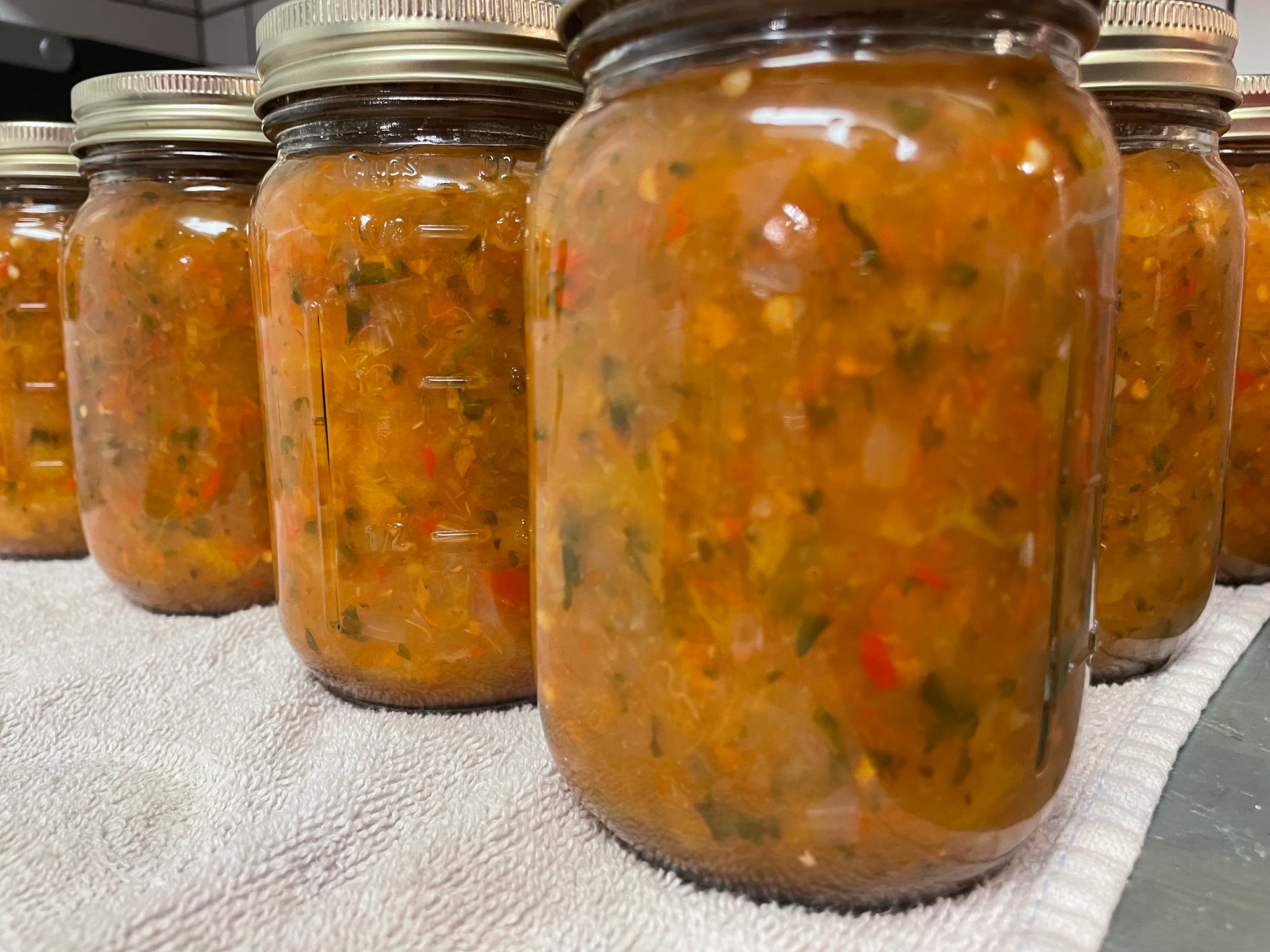 A row of Ginny's Apple Peach Salsa jars