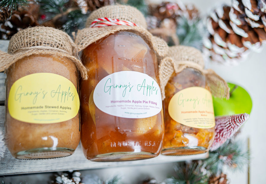 Jars of Ginny's Apples dressed for the holidays with pine cones