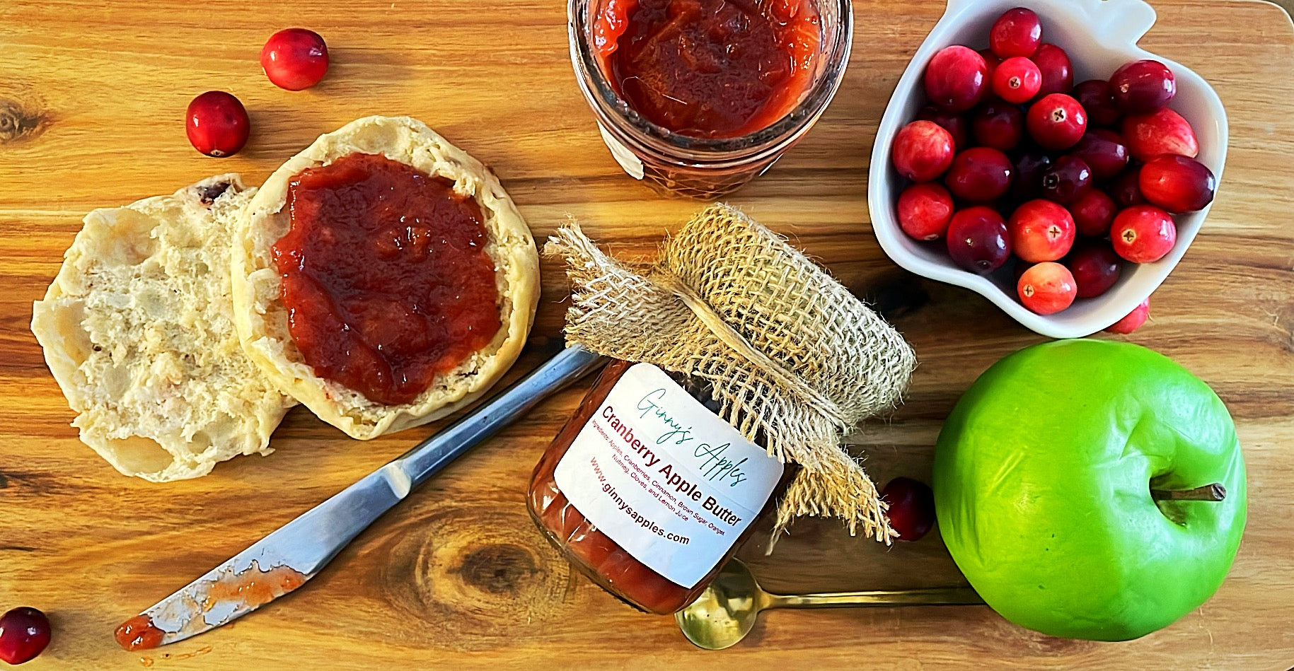 Cranberry Apple Butter spread on a biscuit with cranberries and a green apple