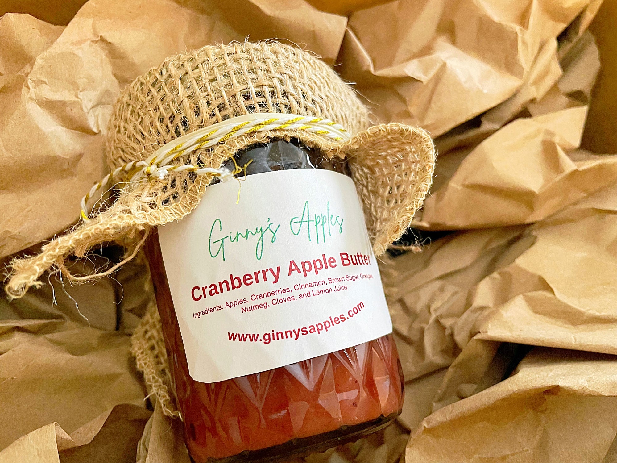 A jar of Ginny's Cranberry Apple Butter wrapped in brown paper